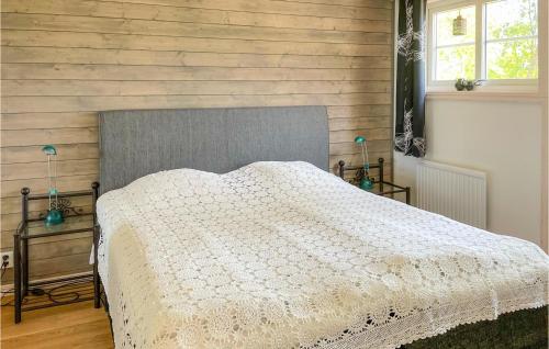 a bedroom with a bed and a wooden wall at Amazing Home In Vittaryd With Wifi in Kvänarp