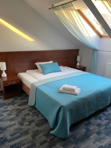 a bedroom with a bed with a blue blanket at Hotel Restauracja Cztery Pory Roku in Orneta