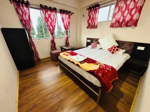a bedroom with a large bed with red curtains at Lava Hills Heaven Homestay in Lava