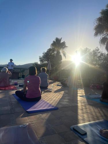 a group of people sitting on the ground watching the sunset at Chez Mamouchthka in Ourika