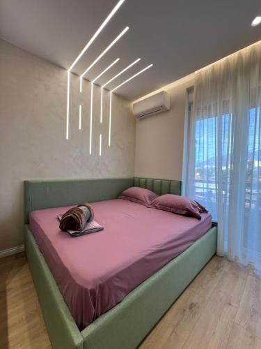 a bedroom with a large bed with a pink blanket at City Center Urban Condo in Tirana