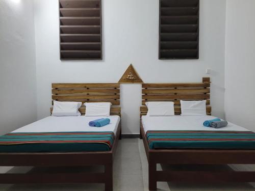 two beds sitting next to each other in a room at Lord Of Beach Resort & Meditation Centre in Batticaloa