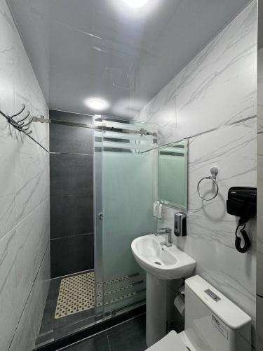 a bathroom with a shower and a sink and a toilet at Light Hotel in Samarkand