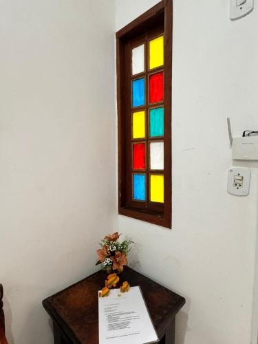 a stained glass window with a table with a sign at Pousada Casa de Buzios in Búzios