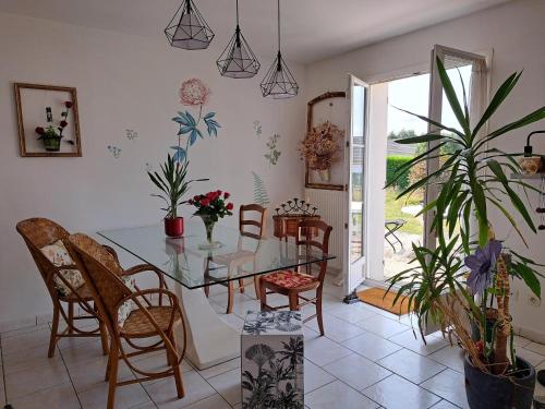 une salle à manger avec une table et des chaises en verre dans l'établissement Chambre au coeur de la Sologne, à Romorantin-Lanthenay