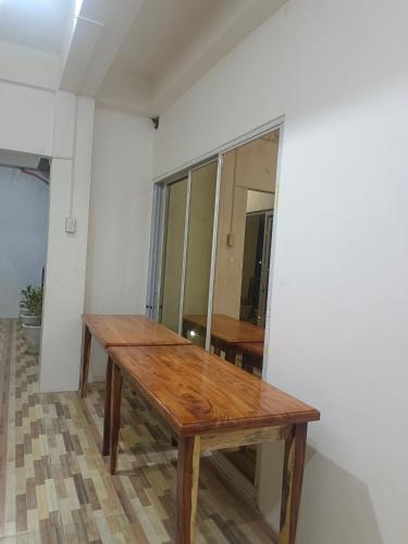 a wooden table in the corner of a room at WARM Tourist Inn in Badian