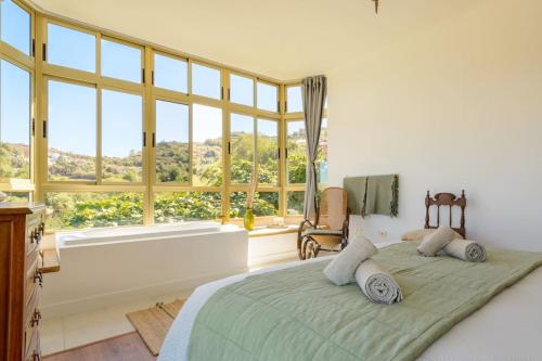 a bedroom with a large bed with a large window at Villa con piscina y vista al mar in Moya