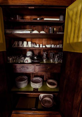 une étagère en bois avec des assiettes et de la vaisselle dans l'établissement Le Clos des Aramons, à Bernis