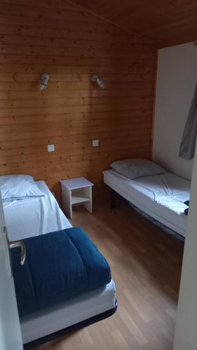 a room with two beds and a table in it at Chalet familial entre les pins in Agde
