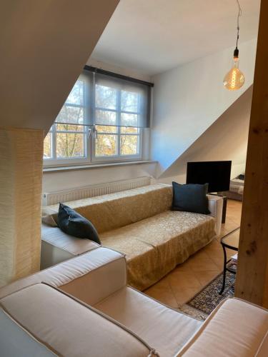 a living room with a couch and a television at Helle und ruhige Dachgeschosswohnung in Munich