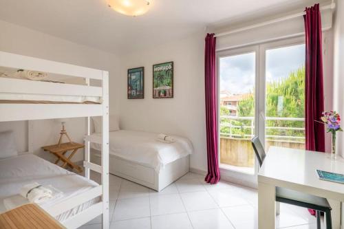- une chambre avec 2 lits superposés, un bureau et une fenêtre dans l'établissement Modern Beachfront family apartment with pool, à Antibes