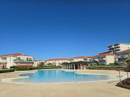 une grande piscine devant certains bâtiments dans l'établissement Modern Beachfront family apartment with pool, à Antibes