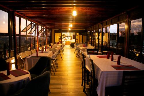 a dining room with tables and chairs and windows at Kaloni Hotels in Seeta