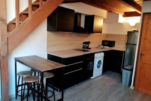 une petite cuisine avec une table et une cuisinière dans l'établissement Studio mezzanine en hyper centre, à Arles