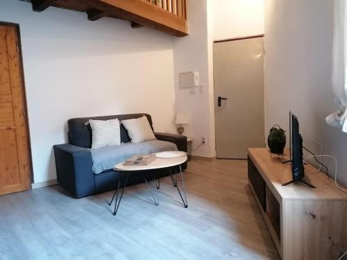 un salon avec un canapé bleu et une table dans l'établissement Studio mezzanine en hyper centre, à Arles