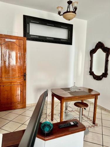 a living room with a table and a mirror at Ambre appartement in Essaouira