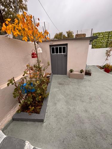 a garage with a door and some plants in front of it at Platanos Village Home in Tríkala