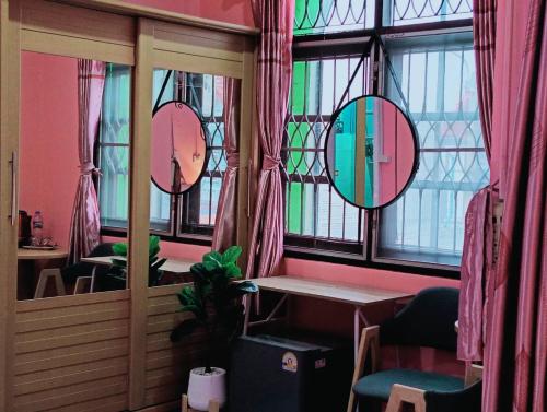 a room with three mirrors and a table and chairs at Ruenthip Homestay in Bangkok