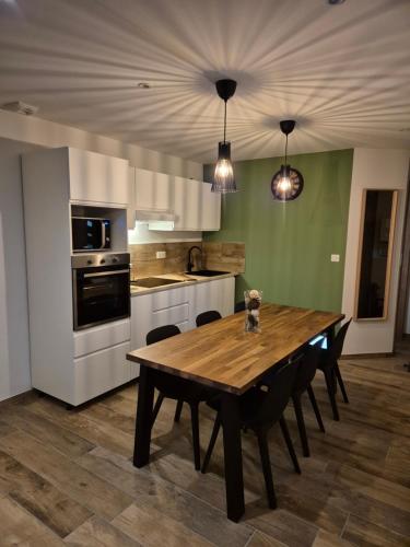 une cuisine avec une table en bois, des chaises et des appareils électroménagers dans l'établissement chez Cyril et Celine, à Tignes