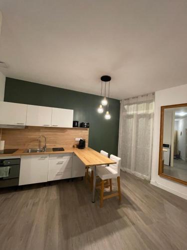 une cuisine avec une table en bois et une table et des chaises dans l'établissement La Suite 82, à Montauban