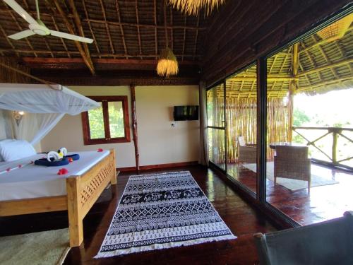 a room with a bed and a room with a balcony at MONKEY MOUNTAIN LODGE in Mtende