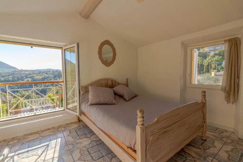 a bedroom with a bed and a large window at Charmante Maison de village- les adrets in Les Adrets de l'Esterel
