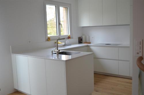 a white kitchen with a sink and a window at VK - H - Zürich Airport - Luxury - Homestay - Haldenstrasse - Kloten in Kloten