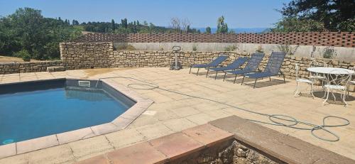 une terrasse avec une piscine, des chaises et une table dans l'établissement Maison Bellevue, à Grane