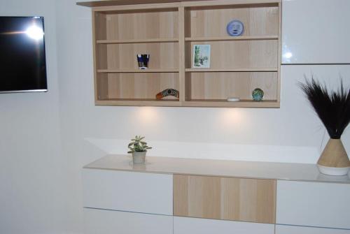 une cuisine avec un comptoir blanc et une étagère dans l'établissement Appartement 40 m2 à, Boulogne Billancourt, à Boulogne-Billancourt