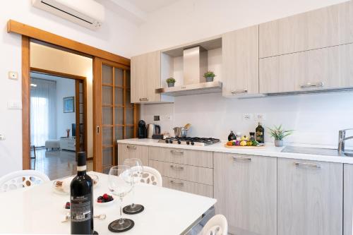 a kitchen with a table with a bottle of wine at Godi Fiorenza Suite - Duomo a 15 Minuti e Aeroporto a 4 Minuti con Tramvia T2 in Florence