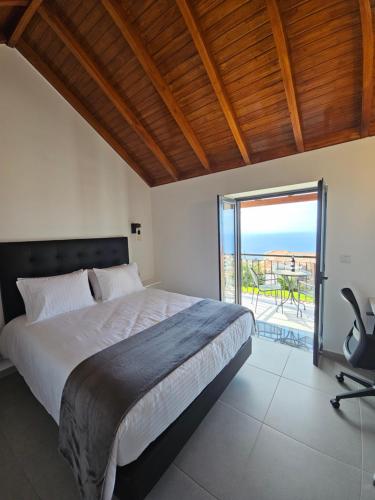a bedroom with a large bed and a balcony at Quinta das Rosas 6 Amaizing Seaview Trekking Beach in Estreito da Calheta