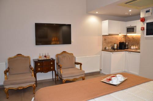 a living room with two chairs and a table and a kitchen at Air Suite in Spáta
