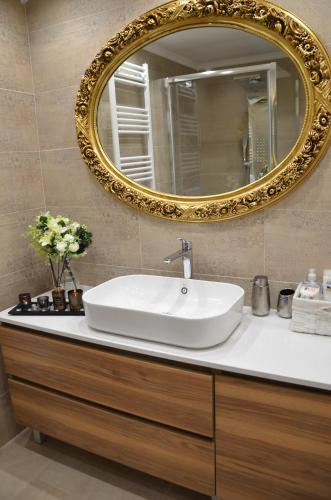 a bathroom with a white sink and a mirror at Air Suite in Spáta