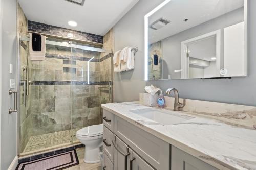 a bathroom with a shower and a sink and a toilet at 233 Edgewater Inn in Charlevoix