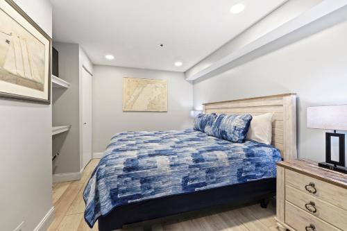 a bedroom with a bed with a blue comforter at 233 Edgewater Inn in Charlevoix