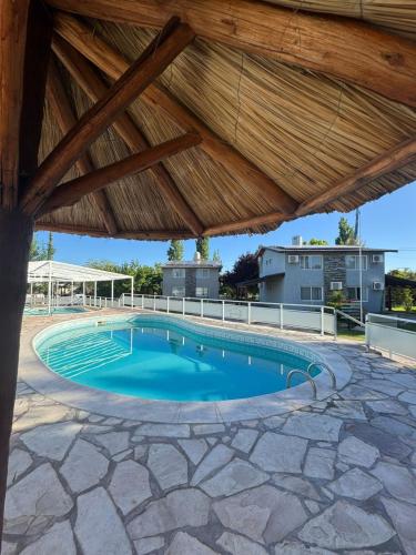 a large swimming pool with a wooden roof at Complejo Turistico Los Troncos in San Rafael