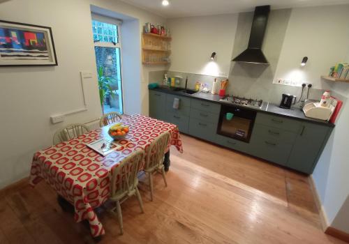 een keuken met een tafel met daarop een schaal fruit bij No 14 -A Cosy Townhouse in Westport in Westport