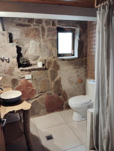 a stone bathroom with a toilet and a window at Balcón serrano 2 in El Volcán