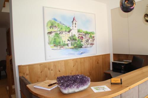 a table in a room with a painting on the wall at Haus Alpenblick in St. Wolfgang
