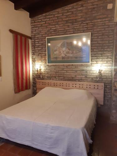 a bedroom with a white bed in a brick wall at La Pink House Salta, Monoambiente amplio y cómodo in Salta