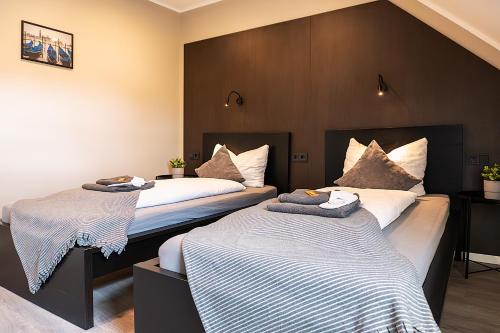 two beds in a hotel room with towels on them at Liro Hotel Viersen in Viersen