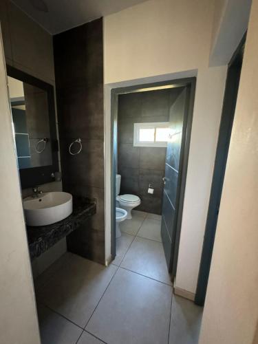 a bathroom with a toilet and a sink at Complejo Turistico Los Troncos in San Rafael