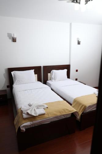 two beds sitting next to each other in a room at Bruti Hotel in Prizren