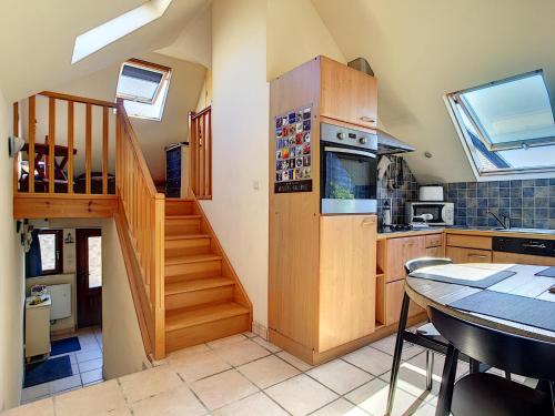 une cuisine avec un escalier en bois et une table de cuisine dans l'établissement Penty Kersiguénou à Crozon - Vue mer, à Crozon