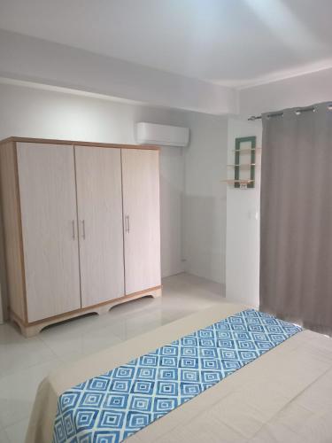 a bedroom with a bed and wooden cabinets at Noah Apartment Flic en Flac in Flic-en-Flac