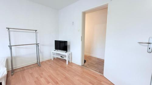 an empty room with a tv on a table in a room at Neumünster Apartments direkt an der Stadthalle mit WLAN & Parkplatz in Neumünster