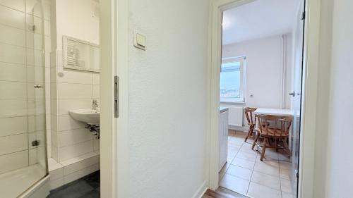 a bathroom with a sink and a toilet and a table at Neumünster Apartments direkt an der Stadthalle mit WLAN & Parkplatz in Neumünster