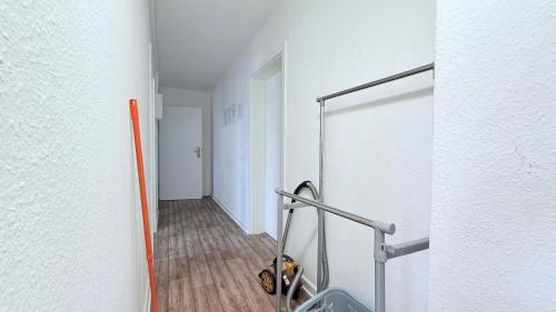 a hallway with a white wall and a white door at Neumünster Apartments direkt an der Stadthalle mit WLAN & Parkplatz in Neumünster
