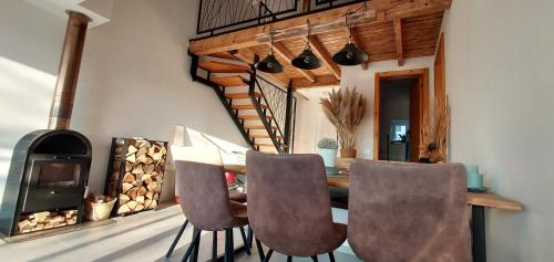 Un comedor con mesa y sillas y chimenea. en Hiša Galeria, en Loče pri Poljčanah