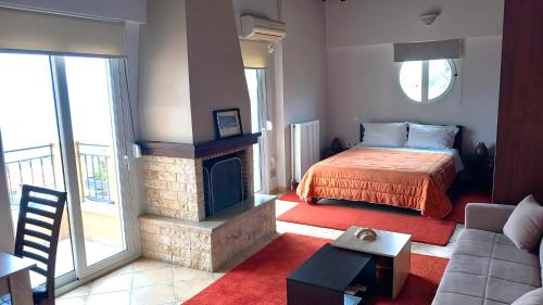 salon z łóżkiem i kominkiem w obiekcie Studio Xanthippe w mieście Kalamos